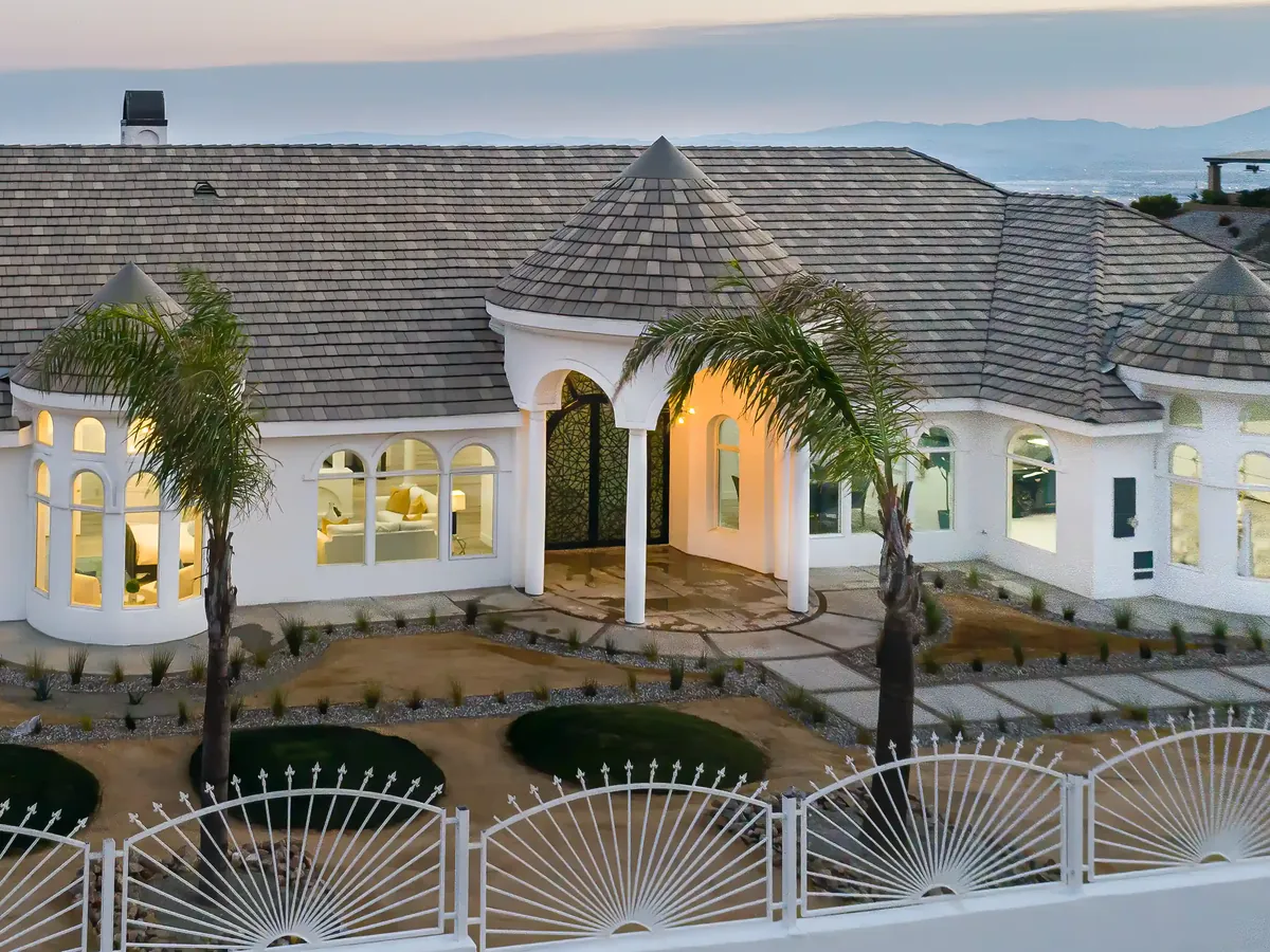 Tile roof with a round turret over the entry of a white stucco home